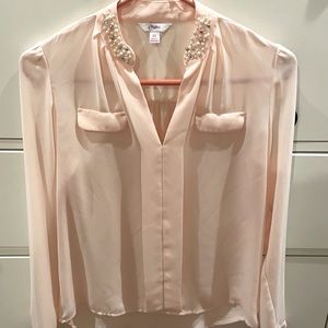 Blush blouse with detail on neck.